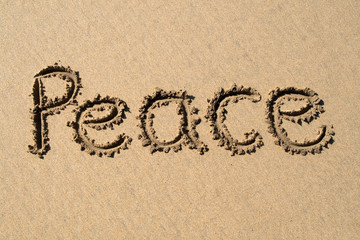 peace, written on a sandy beach.