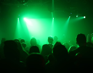 Fototapeta na wymiar tanzende menschen im grünen lichterschein