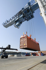crane lowering container to forklift