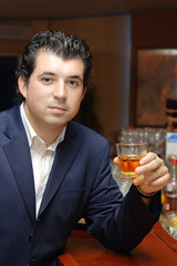 young man in a bar with a glass of whiskey
