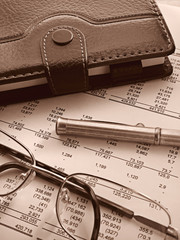 organizer, pen and glasses on financial statement