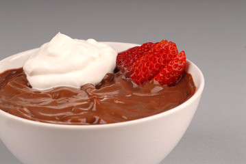 close up of chocolate pudding with whipped cream and a strawberr
