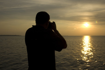 man taking picture of a beautiful sunset