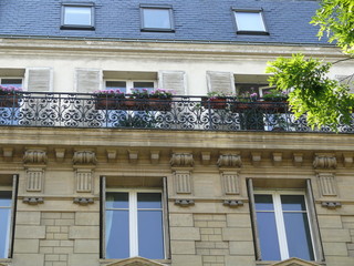 balcon fleuri en haut d'un  immeuble parisien