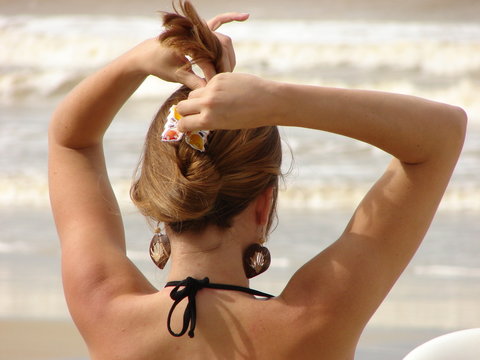 Mulher arrumando cabelo na praia