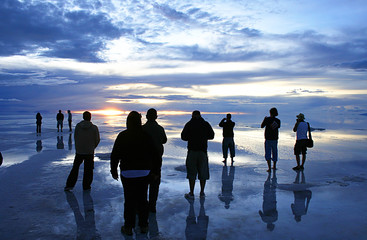 group watching sunset over wet salt flats