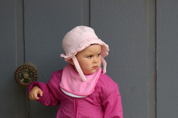 girl in pink by the gray wall