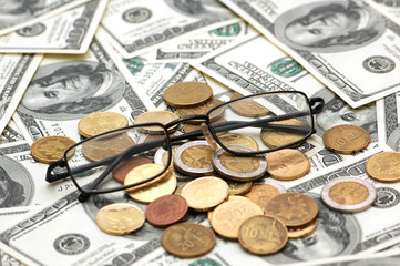 american dollars, reading glasses and various coins