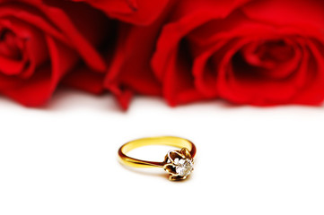 diamond ring and roses at the background