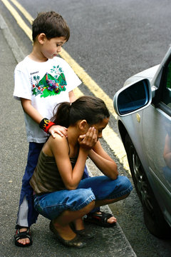 Children by a broken down car