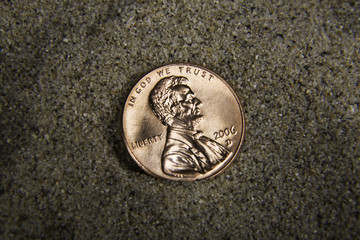 Close up / macro of a US penny in sand, heads side up. - 3546359