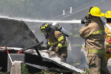 Fire fighters look for victums in debree of burned out home