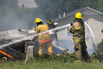 Fire fighters look for victums in debree of burned out home