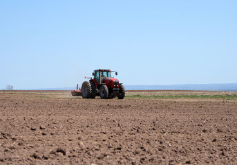Obraz premium Farmer working on him tractor plowing land in spring.