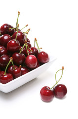 Obraz na płótnie Canvas A filled bowl of cherries over white
