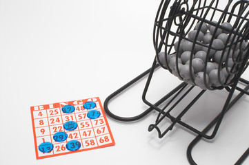 A bingo cage, balls with numbers, card and markers.