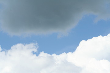clear blue sky line and grey and white clouds as border between dark and light