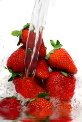 Fresh strawberry jumping into water with a splash