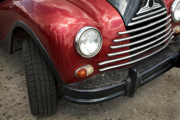 Obraz na płótnie Canvas Piękny i stary czerwony samochód na asfalcie