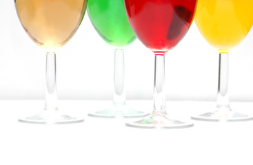 Glasses with drinks of various colours on white