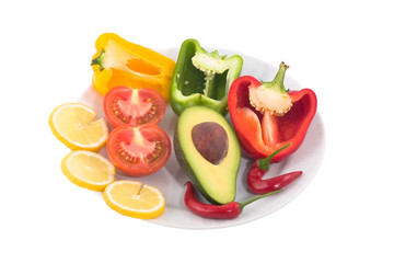 Avocado slices of tomato and lemon pepper on white plate