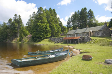 Two fishing boats moored by a row of old fishing lodges 