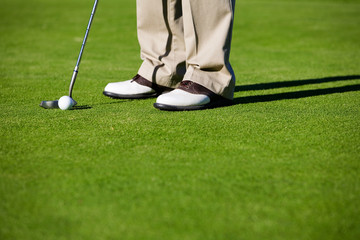 Close-up of man putting golf ball in to hole - 3577936