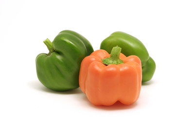 Green and orange bell peppers on white background