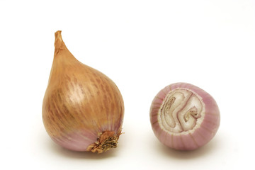Two shallots close-up. One is peeled and cut