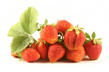 Some strawberries lay on a white background with a leaflet