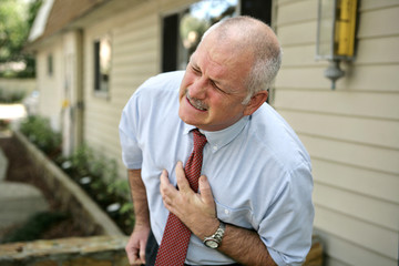 mature businessman clutching his chest