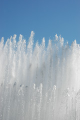 Obraz na płótnie Canvas Water of a city fountain under blue sky