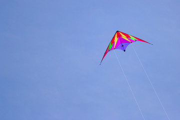 Flying kite against a deep blue sky