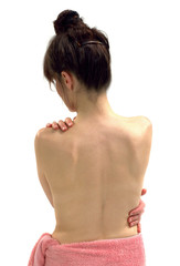 un dos nu de femme devant un fond blanc