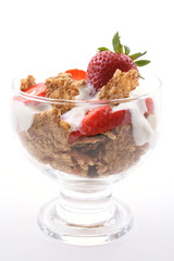 glass of yogurt fresh strawberries and cereals on white