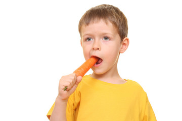 five years old boy eating fresh carrot isolated on white