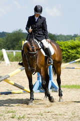 Obraz premium girl on a horse show jumping competition
