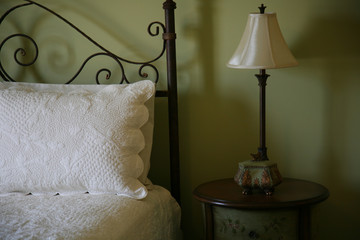 Bedroom with a white comforter and sage green walls
