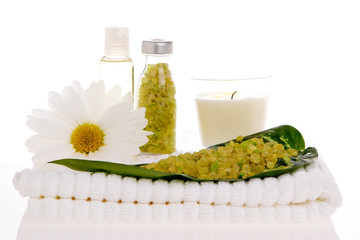 Spa salt, candle, daisy, and bottles