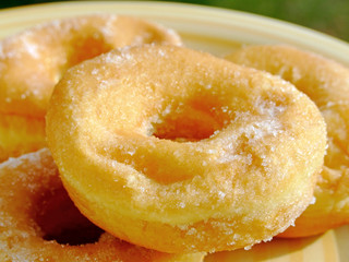 Close-up of some donuts with caster sugar on a dish