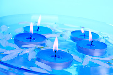 Candles and petals floating in a glass bowl