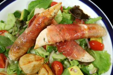 Chicken tenderloins wrapped in prosciutto with a garden salad.