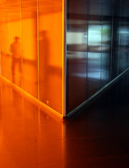 People reflected in angled orange corridor - 3629386