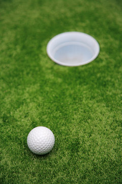 Ball and hole on a floor for a golf