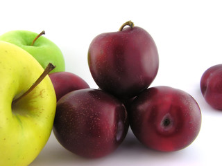 Plums and apples. Isolated on a white background. A close up. 