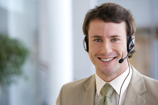 Young smiling businessman on headset