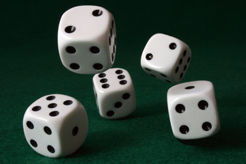 5 dice rolling towards the camera