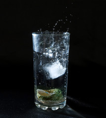Ice splashing water in the glass