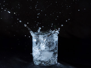 Ice splashing water in the glass