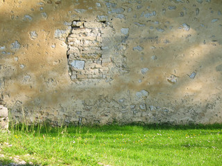 mur de pierre et fenetre bouchée, gazon devant